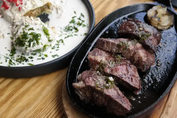 En saftig argentinsk grillfest med perfekt stekt kött och en krämig rätt med örter.