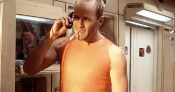 Bruce Willis jako Korben Dallas, jeden z bohaterów "Piątego elementu", rozmawia przez telefon z papierosem w ustach.