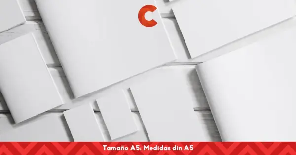 Varias hojas de papel blanco, algunas abiertas y otras cerradas, dispuestas sobre una superficie de madera. Un logo naranja en forma de C destaca en una de las hojas. El texto inferior indica "Tamaño A5: Medidas din A5".