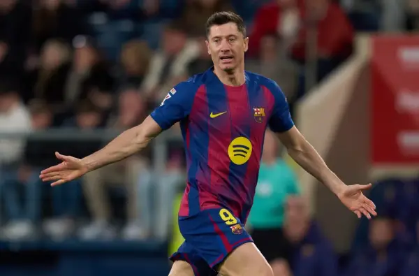 Piłkarz Robert Lewandowski w koszulce FC Barcelony z numerem 9, z rękami rozłożonymi na boki.