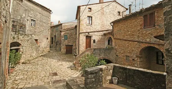 Un vicolo acciottolato a Semproniano, con case in pietra e archi. Un luogo incantevole da esplorare per scoprire cosa vedere.