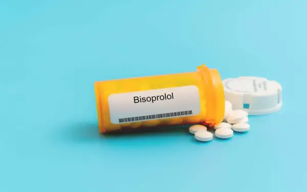Eine Flasche mit Bisoprolol 2,5 mg Tabletten liegt auf blauem Hintergrund.