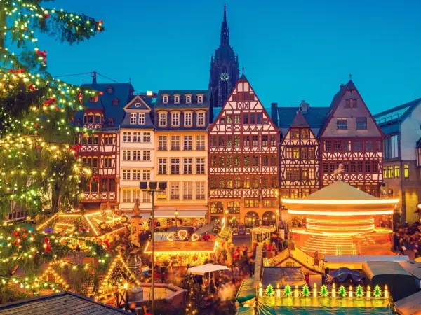 Magiczny jarmark bożonarodzeniowy za granicą. Choinka, karuzela i tradycyjne domy tworzą świąteczną atmosferę.