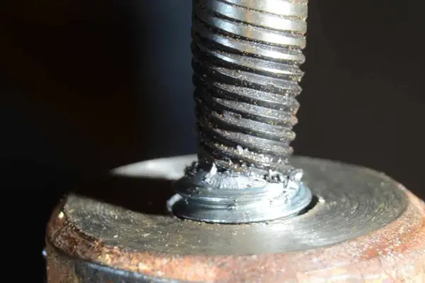 Uszkodzona śruba w aluminiowej obudowie. Widoczne ślady po próbie wykręcenia urwanej śruby z aluminium.