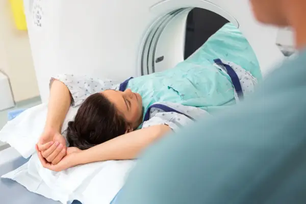 Pacjentka leży w skanerze tomografii komputerowej, badanie może pomóc zdiagnozować metaplazję pęcherza moczowego objawy.