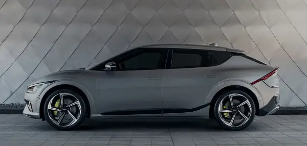 Szary Kia EV6 na tle geometrycznej ściany. Sprawdź atrakcyjną kia ev6 cena i zamów już dziś!