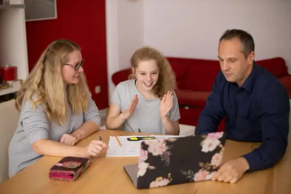 Familie lernt gemeinsam. Die Tochter freut sich über Fortschritte. Nachhilfe Preise pro Stunde sind hier gut investiert.
