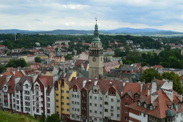 Widok na kłodzko stare miasto z charakterystyczną wieżą zegarową i kolorowymi kamienicami.