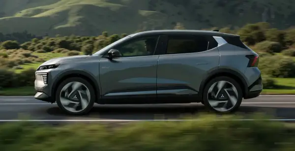 Nowy, elektryczny Mitsubishi Eclipse Cross sunie po malowniczej drodze, otoczony zielonymi wzgórzami.