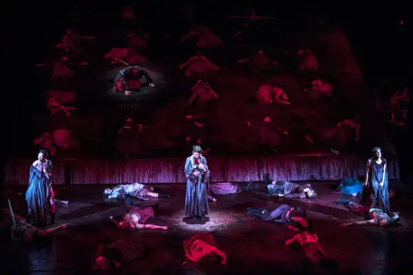 Scena z "Makbeta" w Teatrze Muzycznym Wrocław. Na scenie leżą martwi, stoi postać z dzieckiem.