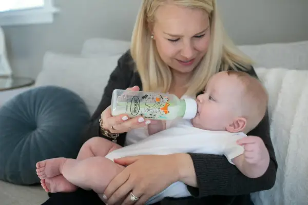 Mama karmi dziecko z butelki antykolkowej Dr Brown's z uroczym motywem lisów.