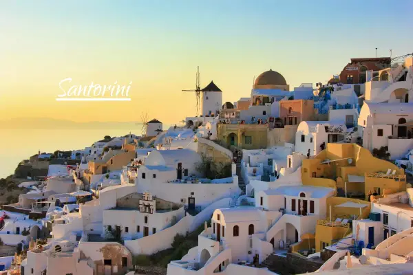 Zachód słońca nad Oia na Santorini. Czy warto? Białe domy, wiatraki i błękitne morze tworzą idylliczny krajobraz.