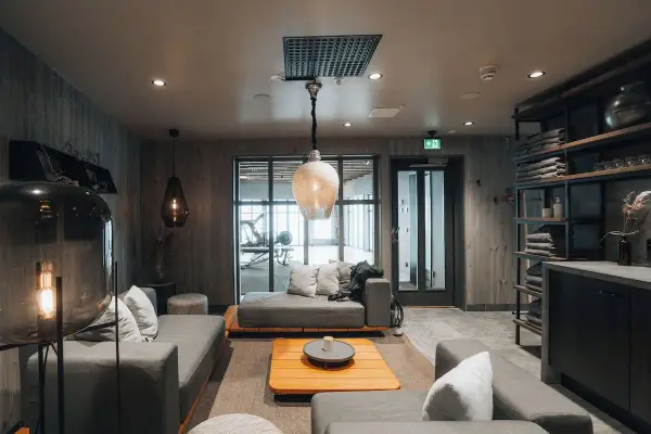 Mysig lounge med soffor och ett gym i bakgrunden på Niehku Mountain Villa.