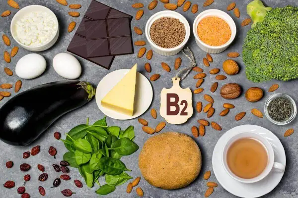 Produkty bogate w witaminę B2: jajka, ser, migdały, czekolada, brokuły, szpinak, soczewica, orzechy, herbata.