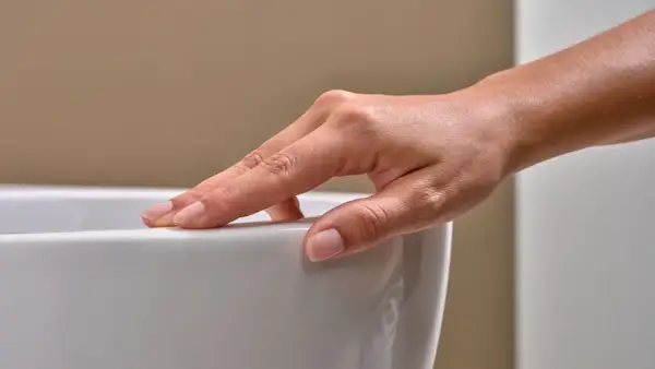 Eine Hand streicht über eine weiße Oberfläche. Mögliche Keratect Nachteile könnten hier eine Rolle spielen, wenn die Oberfläche empfindlich ist.