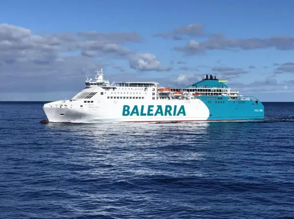 Un gran barco de Baleària navega por el mar azul, rumbo a Mallorca desde Valencia.