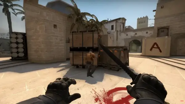 Gracz w Counter-Strike 2 z nożem w ręku, gotowy do ataku na przeciwnika w pustynnej lokacji.