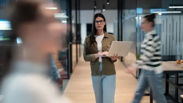 Femme avec un ordinateur portable dans un bureau moderne, préparant une annonce légale changement de gérant.