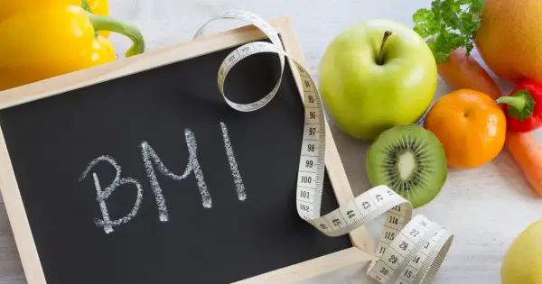 Tablica z napisem BMI, miarka krawiecka i świeże owoce. Zastanawiasz się, ile powinnaś ważyć w ciąży?