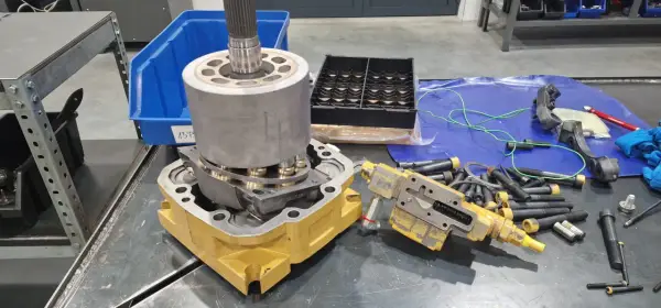 Rozłożone części do naprawy pomp wodnych. Widać elementy hydrauliczne, wał, obudowę i śruby.