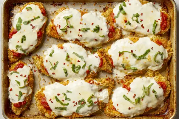 Cotolette di pollo impanate e gratinate con mozzarella filante, salsa di pomodoro e basilico fresco. Un elenco di cibi deliziosi pronti per essere gustati.