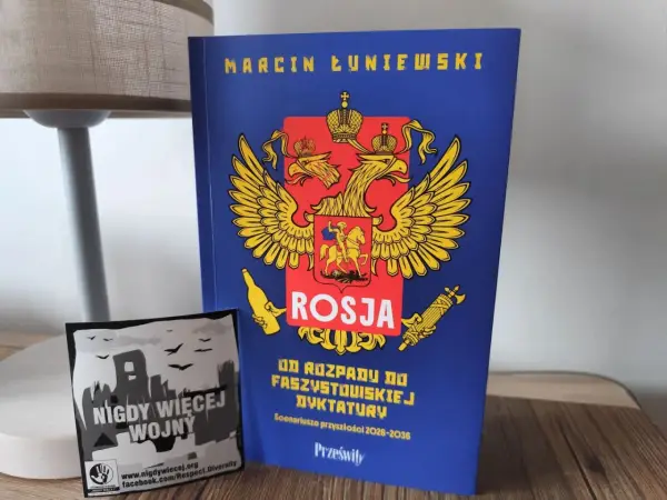 Książka "Rosja od rozpadu do faszystowskiej dyktatury" Marcina Łuniewskiego obok naklejki "Nigdy więcej wojny".