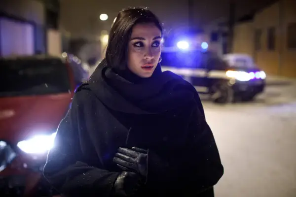 Jana Berzelius står i snö med en polisbil i bakgrunden.