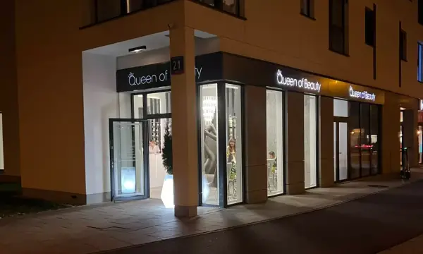 Elegancki salon "Queen of Beauty" nocą. Wnętrze rozświetlone, widać klientki. Czekam na pozytywne queen of beauty opinie!