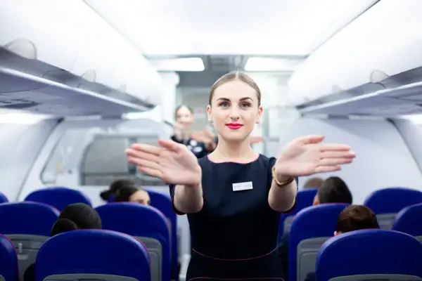 Uśmiechnięta stewardessa Wizzair wita pasażerów. Czy trzeba drukować kartę pokładową Wizzair? Sprawdź przed podróżą!