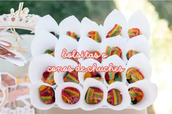 Conos blancos llenos de diferentes tipos de chuches, como gominolas arcoíris y bolitas de colores.