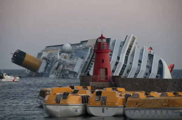 Épaves du Costa Concordia, symbole tragique de la mer. Des canots de sauvetage orange attendent, rappelant le naufrage et ses morts.
