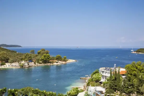 Piękna zatoka w Ksamil, Albania, z turkusową wodą, zielonymi wyspami i białym hotelem. Idealne miejsce na wakacje.
