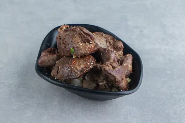 Aksamitna wątróbka z airfryer, doprawiona ziołami, podana w czarnej misce.
