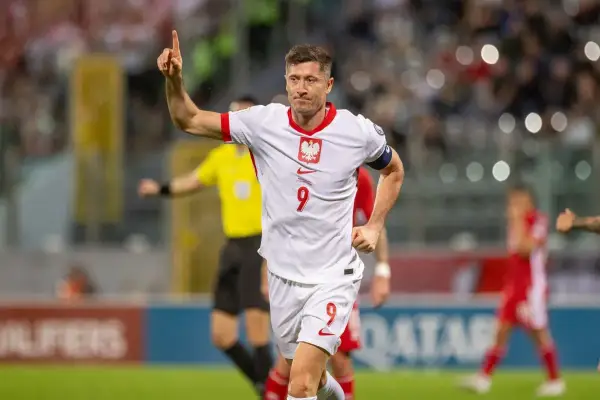 Robert Lewandowski, jeden z najlepszych polskich piłkarzy, świętuje bramkę. Jego biała koszulka z orłem i numerem 9 to symbol dumy narodowej.