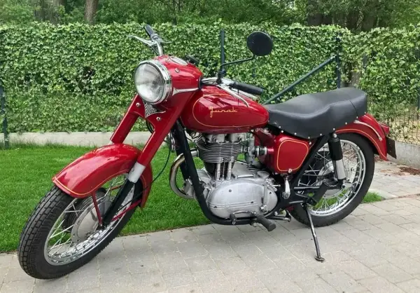 Klasyczny czerwony Junak, jeden z kultowych modele wsk, lśni w słońcu.
