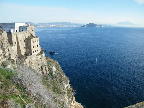 Vue depuis le fort de San Michele à Procida, surplombant la mer bleue. Au loin, des îles et le Vésuve.