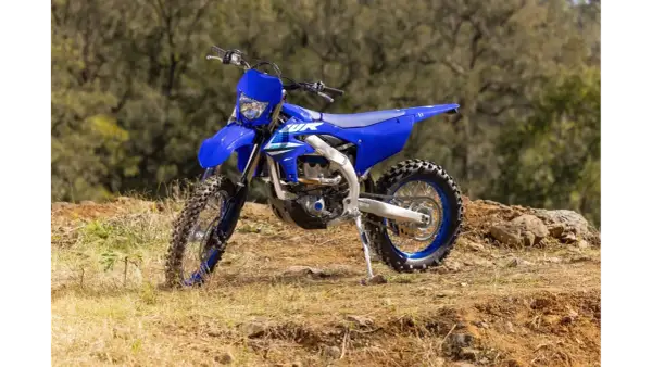 Niebieski motocykl Yamaha WR250F na tle leśnym. Szczegółowe yamaha wr 250 f dane techniczne dostępne dla miłośników off-roadu.