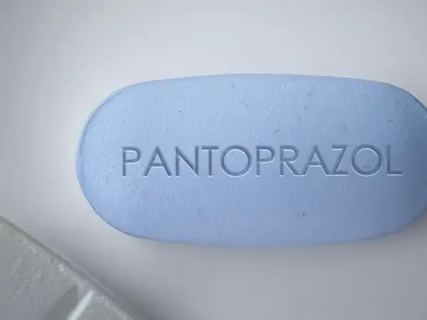 Ein hellblaues Pantoprazol-Tablett mit eingeprägtem Schriftzug. Manche Menschen nehmen Pantoprazol und Magnesium zusammen ein.