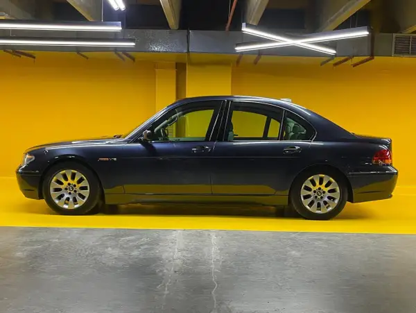 Eleganckie bmw e67 w ciemnym kolorze, zaparkowane na tle jaskrawożółtej ściany.
