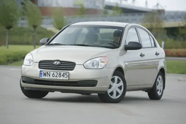 Złoty Hyundai Accent z polskimi tablicami WN 62845 zaparkowany na zewnątrz.
