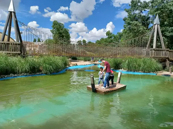Un padre y sus hijos disfrutan de un día de aventura en un parque acuático en Valladolid con niños, navegando en una balsa.