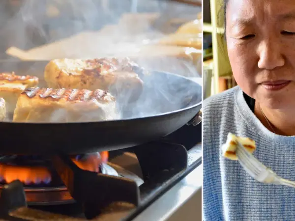 Halloumi steks i panna på spisen, ånga stiger. En kvinna njuter av en bit grillost på en gaffel. Ett enkelt grillost recept.
