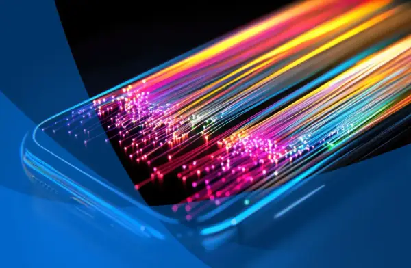 Światłowody w kolorach tęczy wychodzące z telefonu, symbolizujące, co znaczy internet mobilny: szybki i wszechobecny.