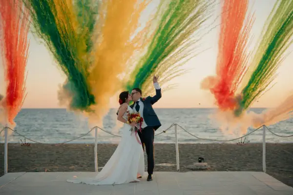Para młoda całująca się na tle kolorowych fajerwerków na plaży.