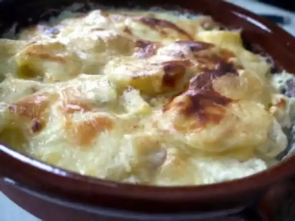 Pommes de terre, lardons et fromage raclette gratinés au four, un plat réconfortant et savoureux.