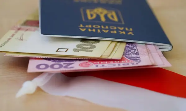 Ukraiński paszport z pieniędzmi, symbolizujący nadzieję na godną emeryturę dla Ukraińców.