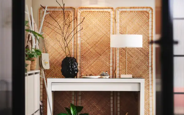 Skapa en mysig atmosfär och designa ditt rum med en vit hylla, en svart vas med grenar och en stilren lampa.