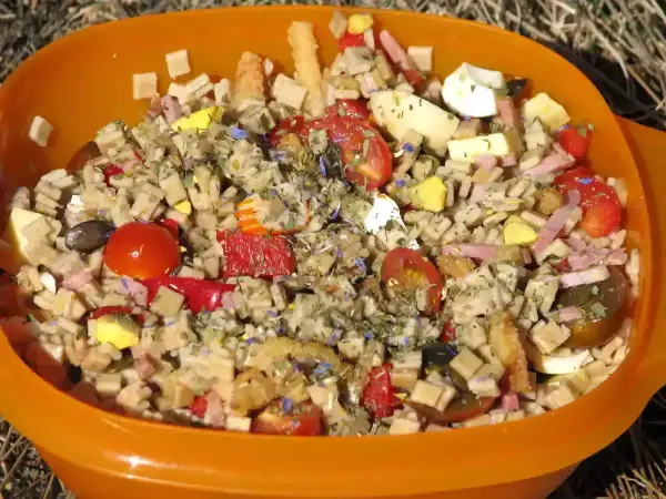 Salade de crozets au thon, garnie de tomates cerises, œufs durs, jambon et herbes. Un plat coloré et savoureux.