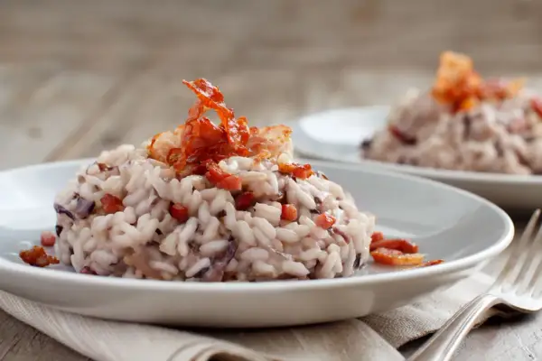 Risotto cremoso con radicchio e croccante guanciale, un'ottima idea su cosa mangiare a Treviso.