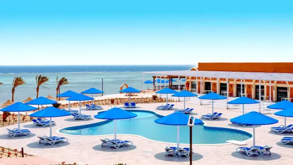 Basen z niebieskimi parasolami i leżakami, widok na morze. Idealne miejsce na wakacje, jak w Pickalbatros Portofino Marsa Alam.